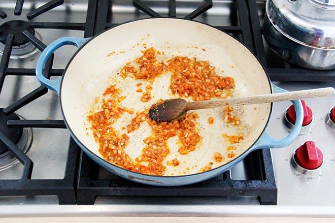 A skillet with harissa rice ingredients all stirred together.