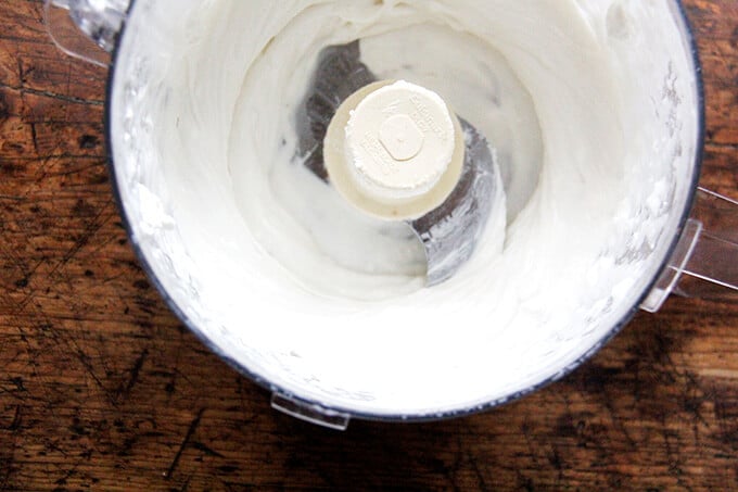 A food processor holding whipped honey goat cheese.