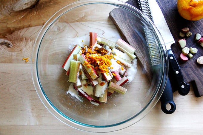 A bowl of chopped rhubarb, orange zest and sugar.