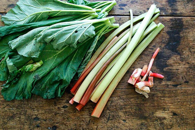 A board with rhubarb and rhubarb leaves.