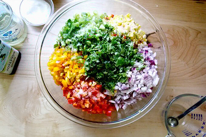 A bowl with Texas caviar ingredients plus olive oil, vinegar, salt, and fresh lime juice.