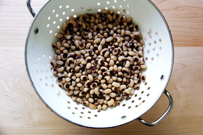 A colander filled with black eyed peas.