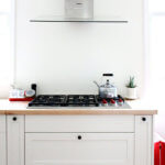 A photo of a Wolf range and a Miele hood.
