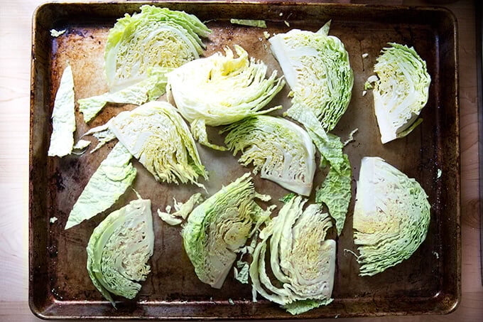 A sheet pan with Savoy cabbage wedges on top.