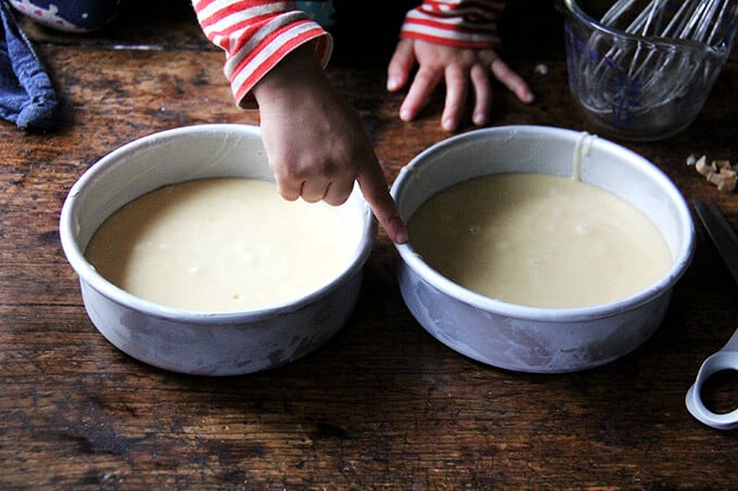 Two small cake pans filled with cake batter.