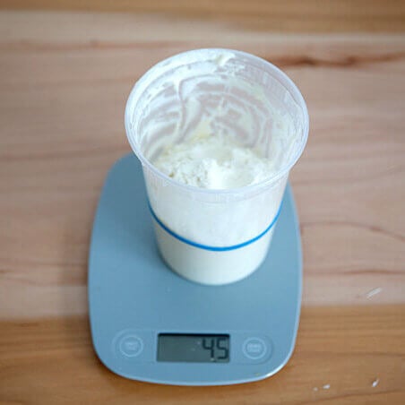 feeding the sourdough starter with flour