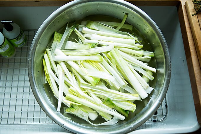 A large bowl filled with leeks soaking in water.