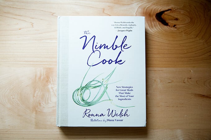 A cookbook, The Nimble Cook, on a counter.