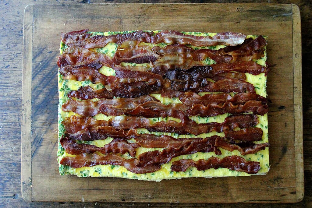 Adding the bacon to the sheet pan sandwich.