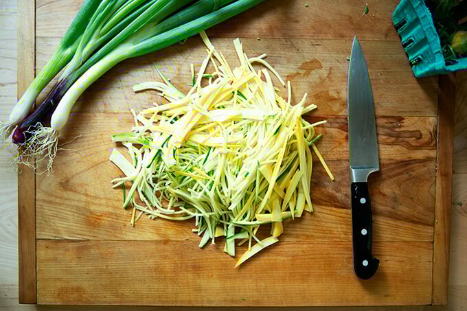 A board with thinly sliced zucchini.