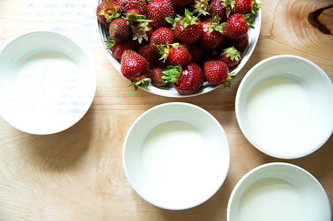 A bowl of strawberries + 4 bowls of cream.
