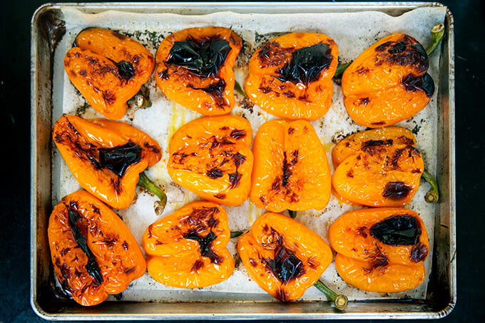 A sheet pan with blistered orange bell peppers.