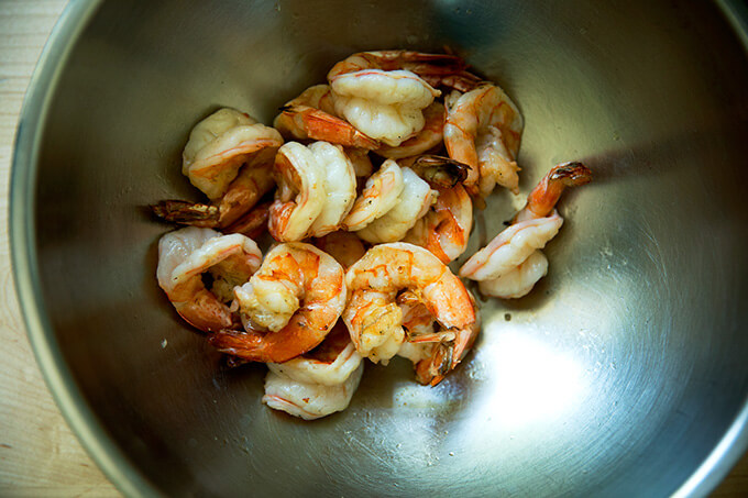 A bowl with grilled shrimp in it.