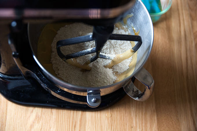 A stand mixer with butter, brown sugar, eggs, vanilla, and dry ingredients for gluten-free chocolate chip cookies.