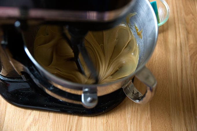 A stand mixer with the wet ingredients for gluten-free chocolate chip cookies all whisked together.