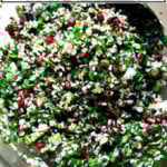 A white serving bowl filled with winter tabbouleh and roasted delicata squash slices.