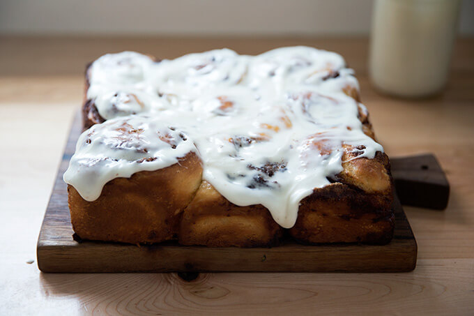 Brioche cinnamon buns, frosted with cream cheese frosting.