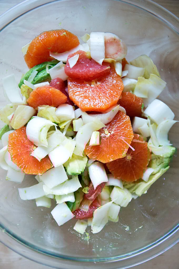 Citrus, avocado, endive in a bowl, seasoned with sea salt and tossed together.