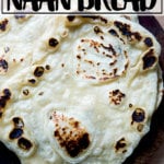 A stack of homemade, yeasted naan on a board.