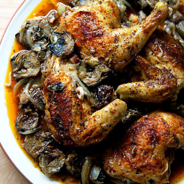 A platter of roast chicken with dates and artichoke hearts.
