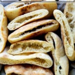 A bowl of cut open rounds of pita bread.