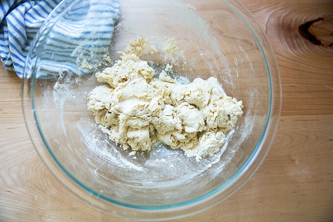 A shaggy pita bread dough in a large bowl.