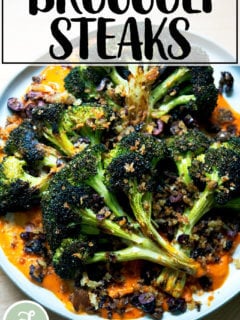A plate of roasted broccoli steaks topped with olive bread crumbs.