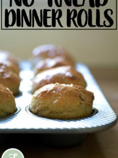 Just-baked thyme dinner rolls in a muffin tin.