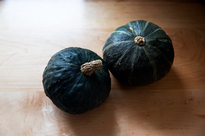 Two Kabocha squash on a countertop.