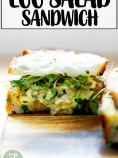 An egg salad sandwich on a board.