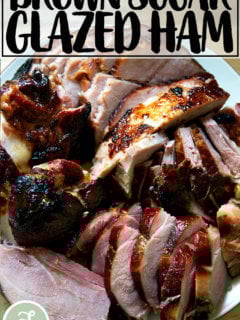 A carved brown sugar glazed ham on a platter.