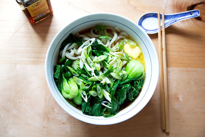 A bowl of life changing udon noodles with bok choy.