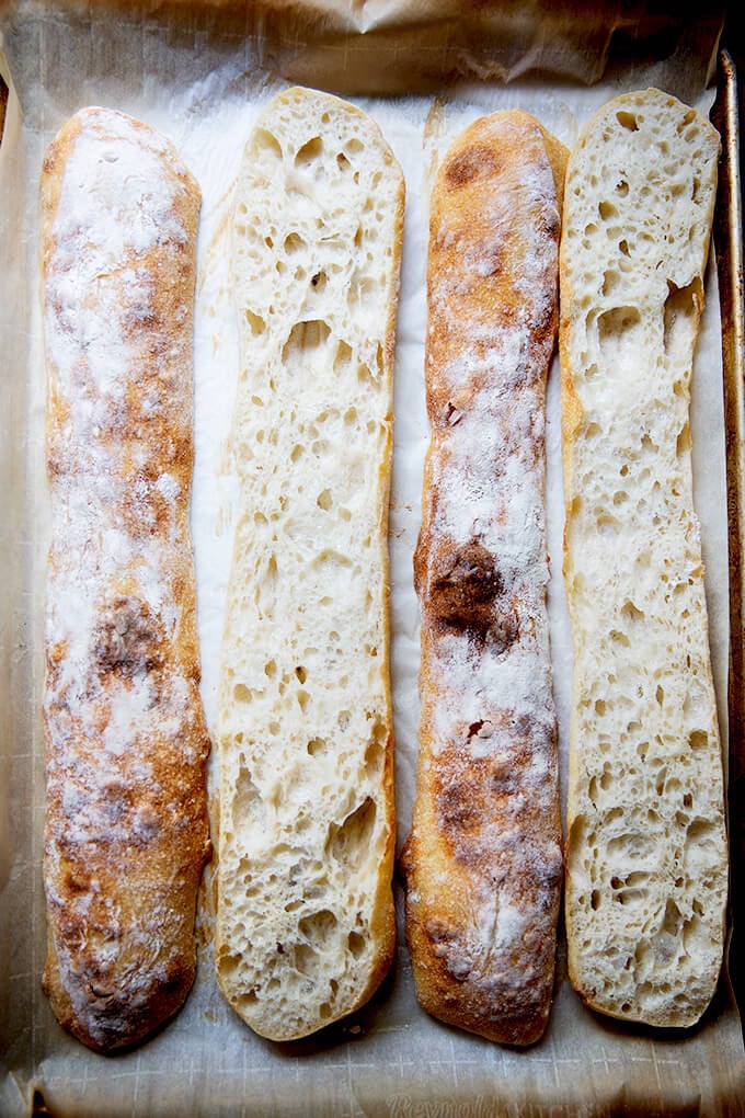 Halved sourdough ciabatta baguettes on a sheet pan.
