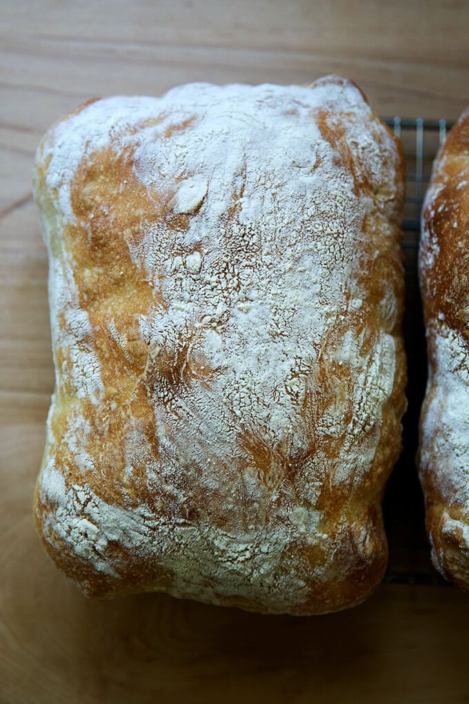 A loaf of ciabatta on a cooling rack.