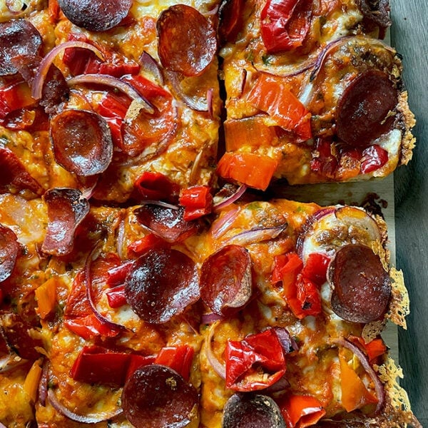 A just-baked Detroit-style pizza on a board.