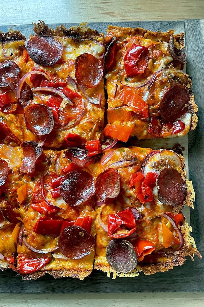 A just-baked Detroit-style pizza on a board.