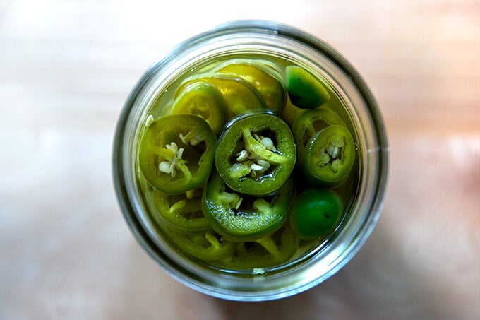 An overhead shot of pickled jalapeƱos in a jar.