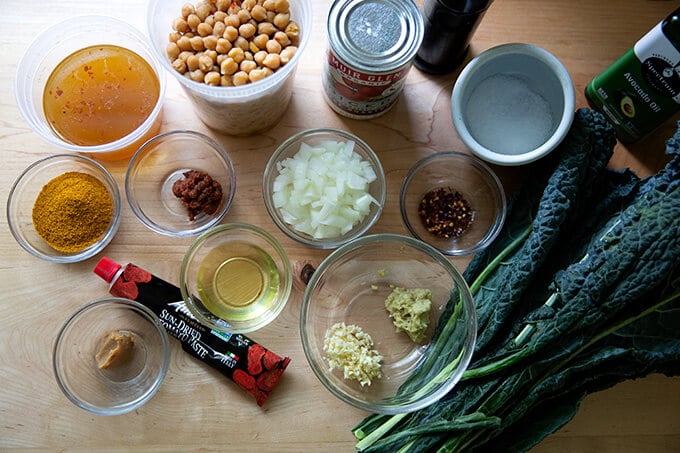 The ingredients to make spicy chickpeas with tomatoes and kale.