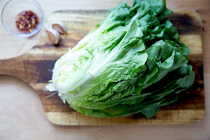 A head of escarole on a cutting board.