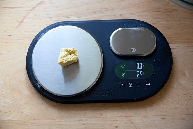 A scale topped with a 25-gram portion of corn tortilla dough.