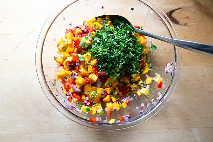 A large bowl of mango salsa in the works, cilantro just added.