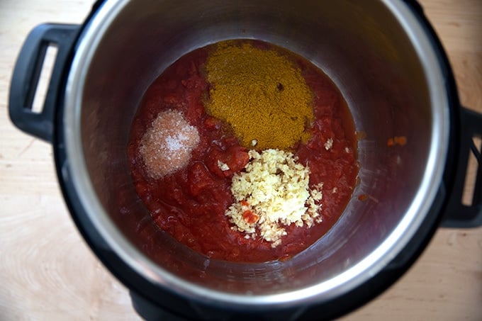 An Instant Pot filled with the sauce ingredients to make butter chicken.
