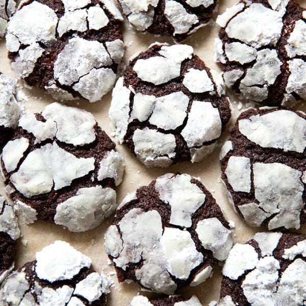 Just baked chocolate crinkle cookies on a sheet pan.