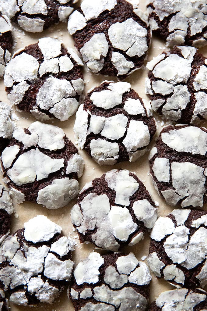 Just baked chocolate crinkle cookies on a sheet pan.