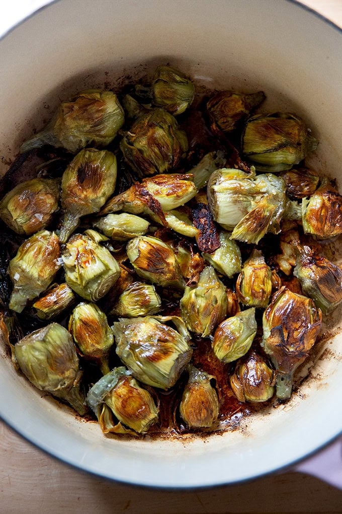 A large pot filled with just-cooked baby artichokes.