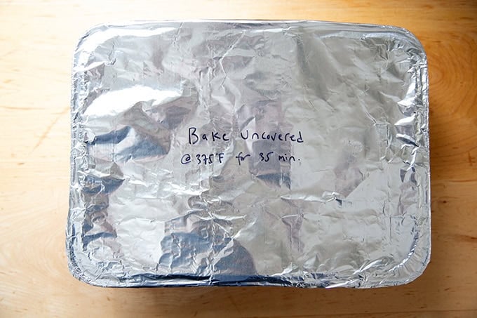 A foil-wrapped unbaked baked pasta with instructions penned with a sharpie on the top.