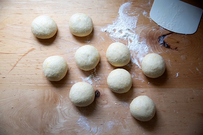Nine balled-up dough balls of hot cross buns.