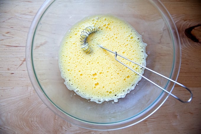 Three beaten eggs in a large bowl.