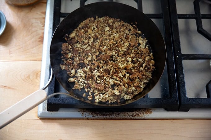 A skillet filled with browned tofu crumbles.