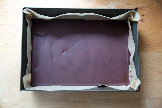 A layer of chilled set dark chocolate in a 10x14-inch pan.